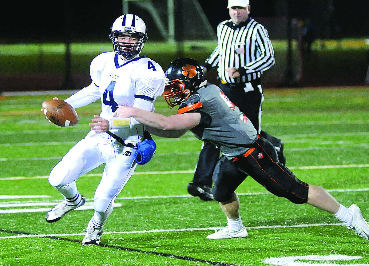 Photo by John Nash - Wilton quarterback RJ Romeo (4) was chased around by Ridgefield's defense last season, but he won't have to worry about his senior year as changes to the FCIAC schedule will keep the two archrivals off the field.