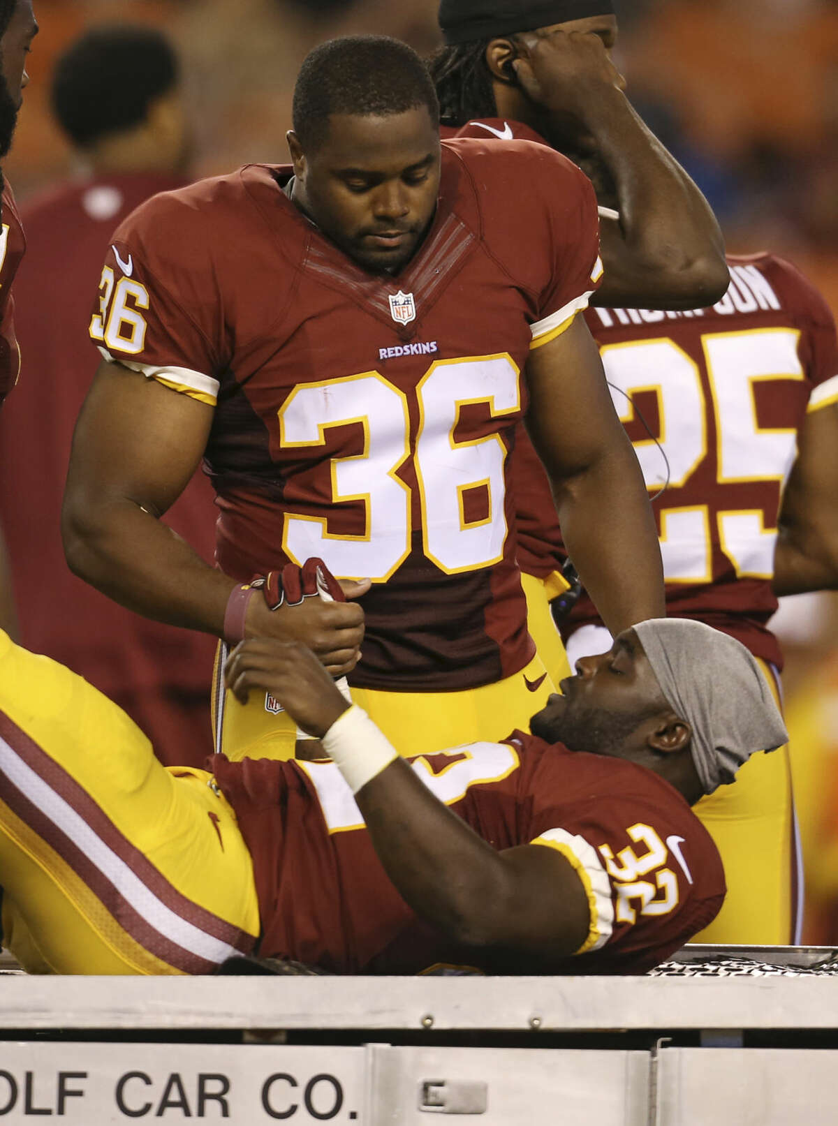 Washington Redskins running back Silas Redd Jr. (32) is consoled by defensive back Tanard Jackson (36) after Redd was injured in the third quarter of an NFL preseason football game against the Cleveland Browns, Thursday, Aug. 13, 2015, in Cleveland. (AP Photo/Ron Schwane)