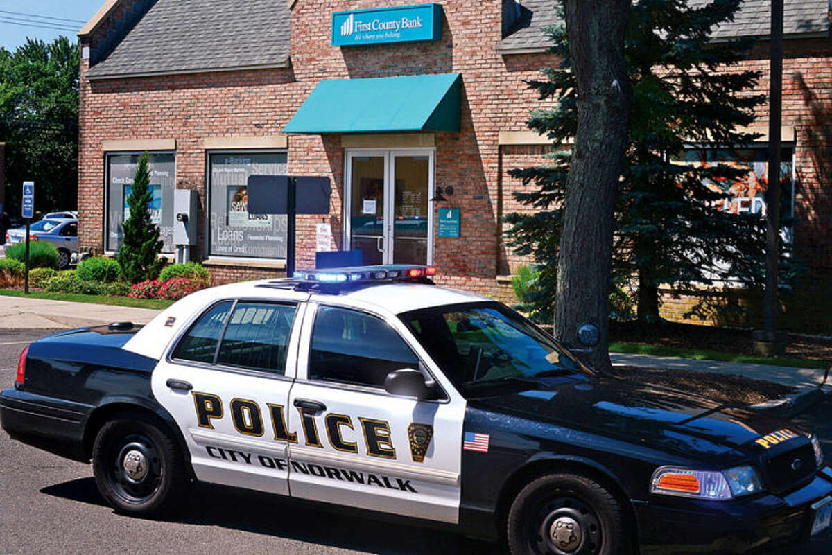 Hour photo / Erik Trautmann Norwalk police investigate a robbery at The First County Bank on Westport Ave Thursday.