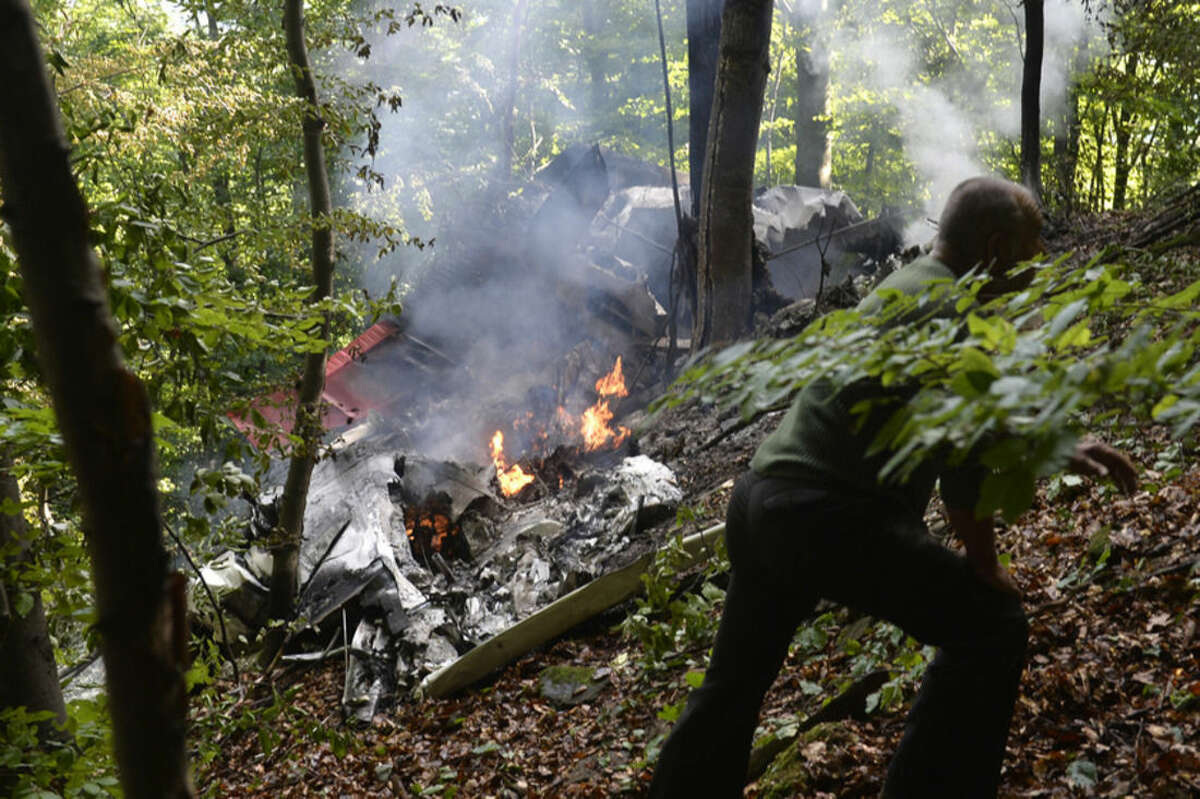 The burning debries of a light aircraft photographed near the village of Cerveny Kamen, Slovakia Thursday, Aug. 20, 2015.Two planes carrying dozens of parachutists collided in midair over western Slovakia, killing several people, officials said. Slovak media reported more than a dozen other parachutists missing and an aviation official said some reportedly survived by jumping out with their parachutes. ( Radovan Stoklasa /TASR via AP)