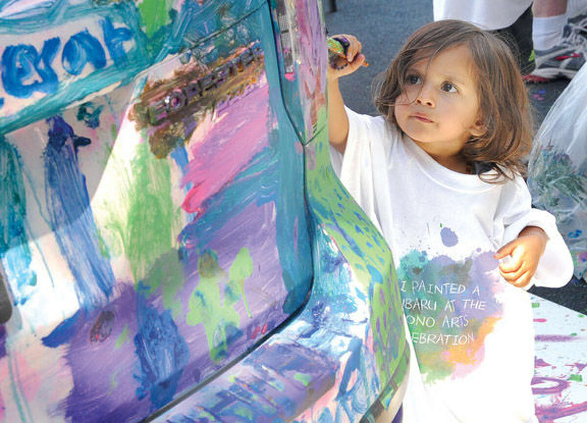 Cariad Samy 2, paints a donated car from Garavel Auto Group Sunday at the SoNo Arts Festival. Hour photo/Matthew Vinci