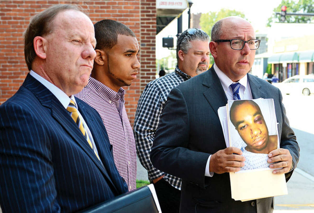Hour photo / Erik Trautmann Attorneys Todd Haase and Phil Russell and private investigator William Smith announce lawsuit for Norwalk police brutality victim Cody Greene, second from left, during a press conference on South Main Street Friday.