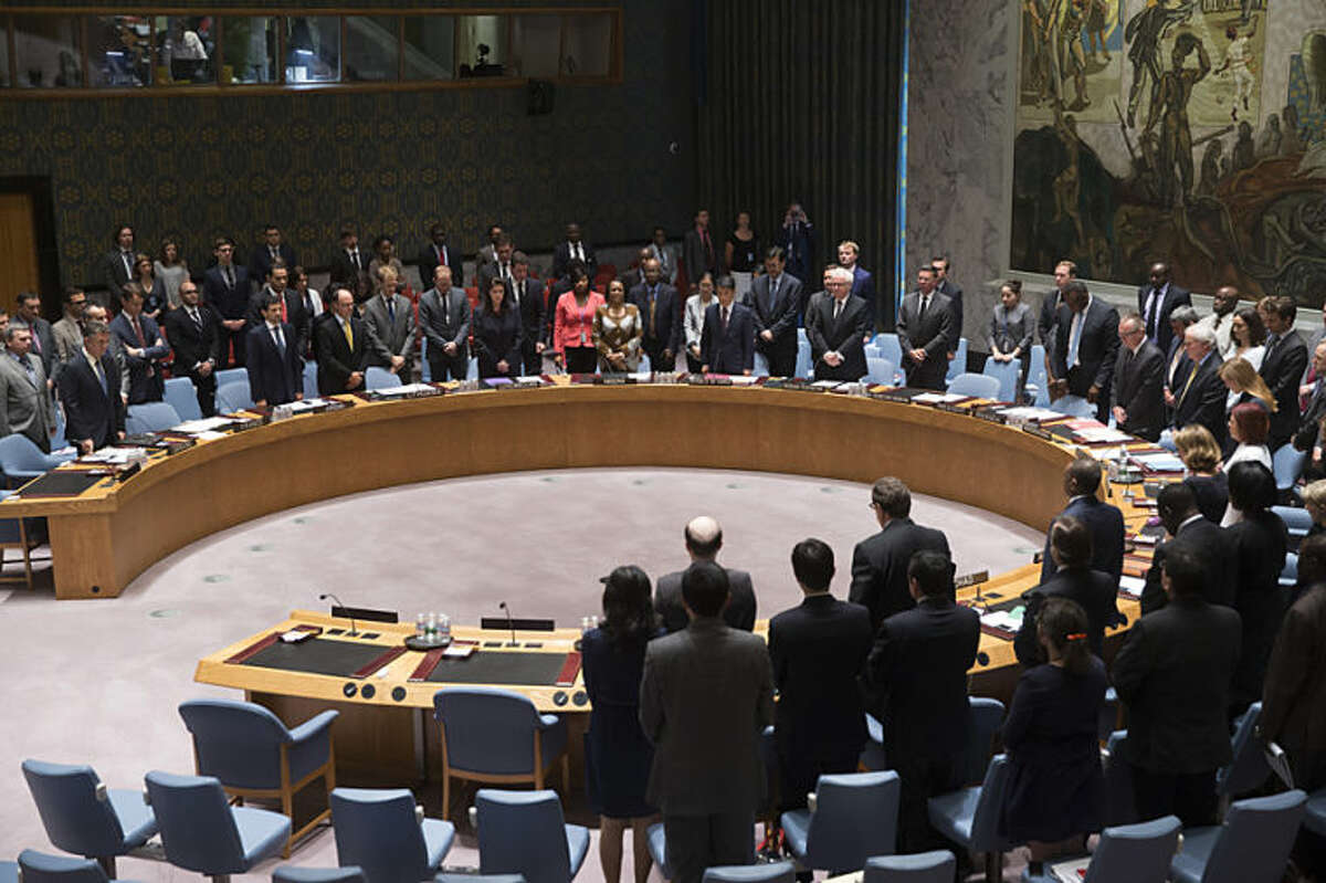 Members of the U.N. Security Council stand for a moment of silence for the lives lost on Malaysia Airlines Flight 17 on Thursday during a meeting at United Nations headquarters, Friday, July 18, 2014. Britain's U.N. Mission says it requested an emergency meeting after Thursday's downing of a Malaysia Airlines plane carrying 298 people over eastern Ukraine. (AP Photo/John Minchillo)