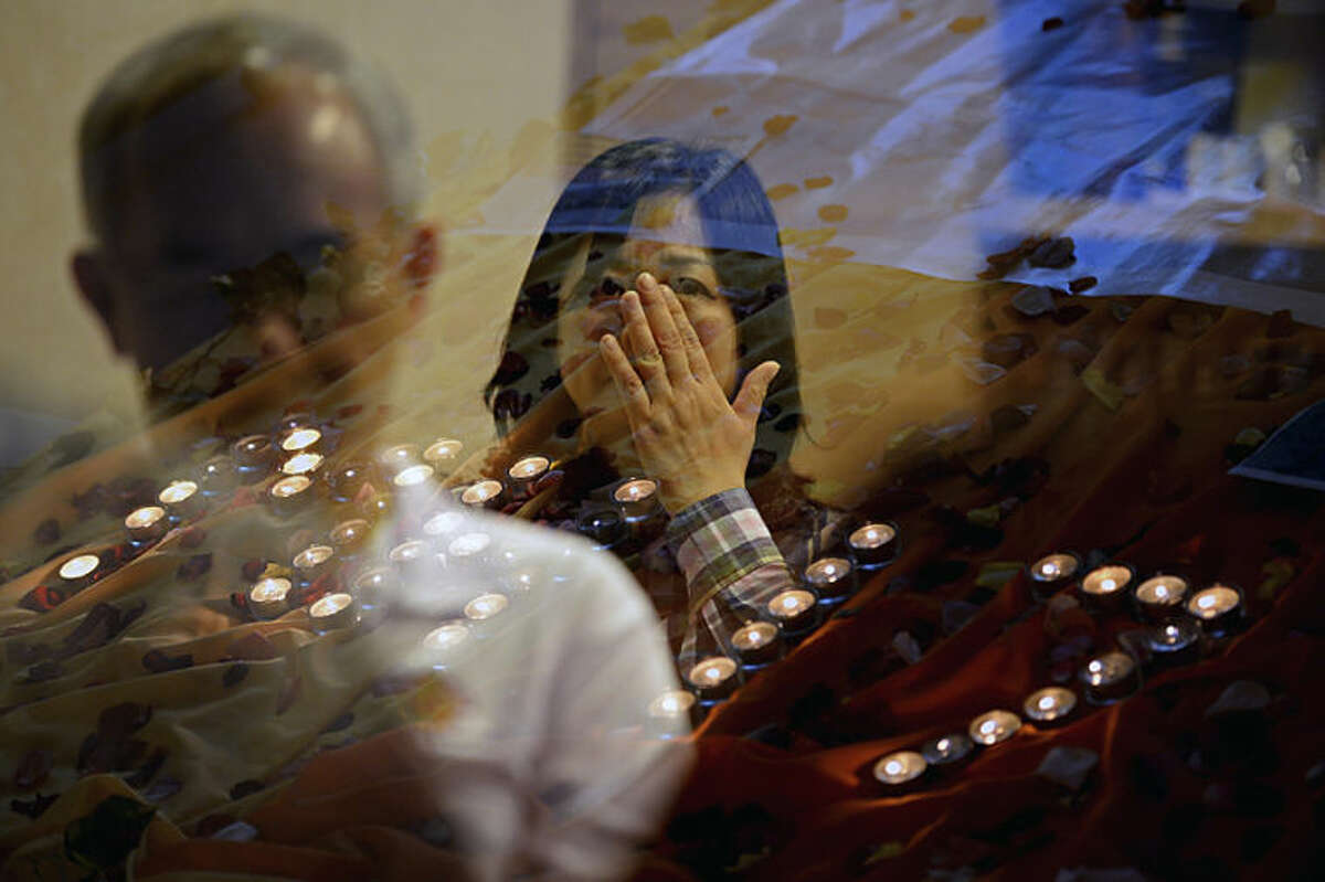 People pray for the victims of Malaysia Airlines Flight 17 at a church outside Kuala Lumpur, Malaysia, Friday, July 18, 2014. The Boeing 777 was carrying 298 people when it was shot down over eastern Ukraine on Thursday in eastern Ukraine, sending shockwaves around the world from Malaysia to the Netherlands. (AP Photo/Joshua Paul)