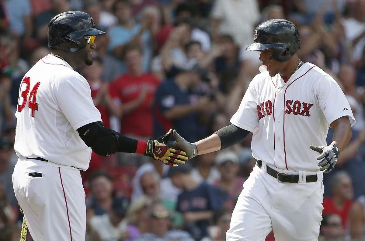 Boston Red Sox's Xander Bogaerts, right, celebrates his solo home run with teammate David Ortiz (34) during the third inning of a baseball game against the Seattle Mariners in Boston, Sunday, Aug. 16, 2015. (AP Photo/Michael Dwyer)