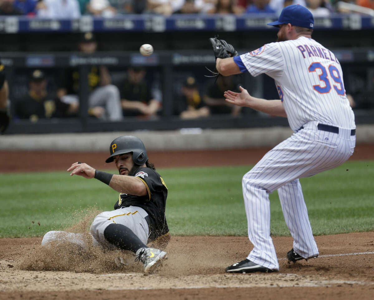Pittsburgh Pirates' Sean Rodriguez, left, scores past New York Mets relief pitcher Bobby Parnell on a passed ball during the seventh inning of the baseball game at Citi Field, Sunday, Aug. 16, 2015, in New York. (AP Photo/Seth Wenig)
