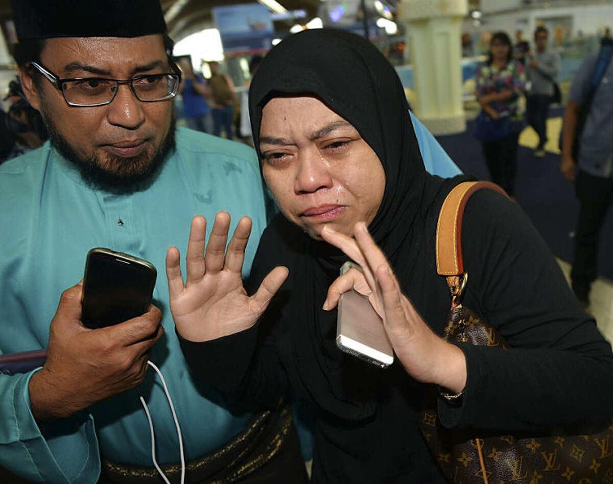 Relatives of passengers aboard the Malaysia Airlines Flight 17 react as they arrive at Kuala Lumpur International Airport in Sepang, Malaysia, Friday, July 18, 2014. The Malaysia Airlines jetliner that went down in war-torn Ukraine did not make any distress call, Malaysia's prime minister said Friday, adding that its flight route had been declared safe by the global civil aviation body. (AP Photo) MALAYSIA OUT