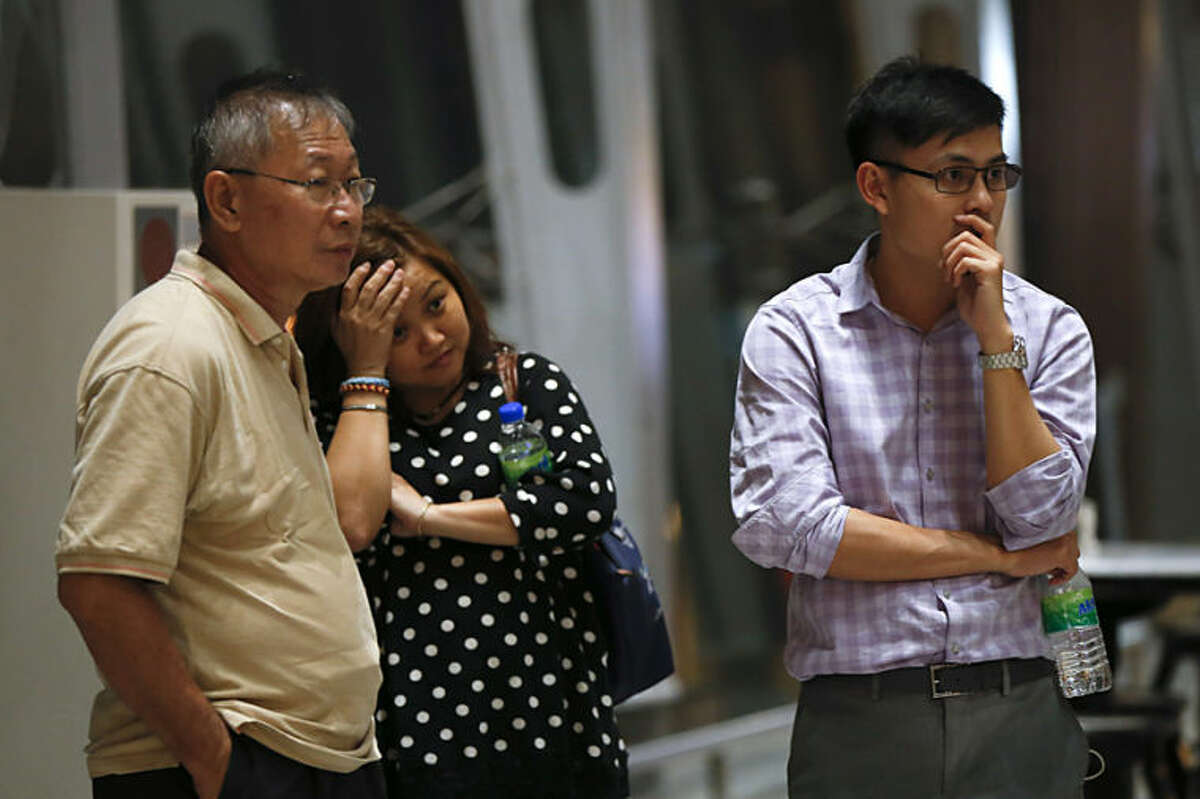 People react as they wait for news after a Malaysia Airlines plane crashed in eastern Ukraine, at Kuala Lumpur International Airport, in Sepang, Malaysia, Friday, July 18, 2014. Ukraine said a passenger plane carrying 295 people was shot down Thursday as it flew over the country, and both the government and the pro-Russia separatists fighting in the region denied any responsibility for downing the plane. (AP Photo/Vincent Thian)