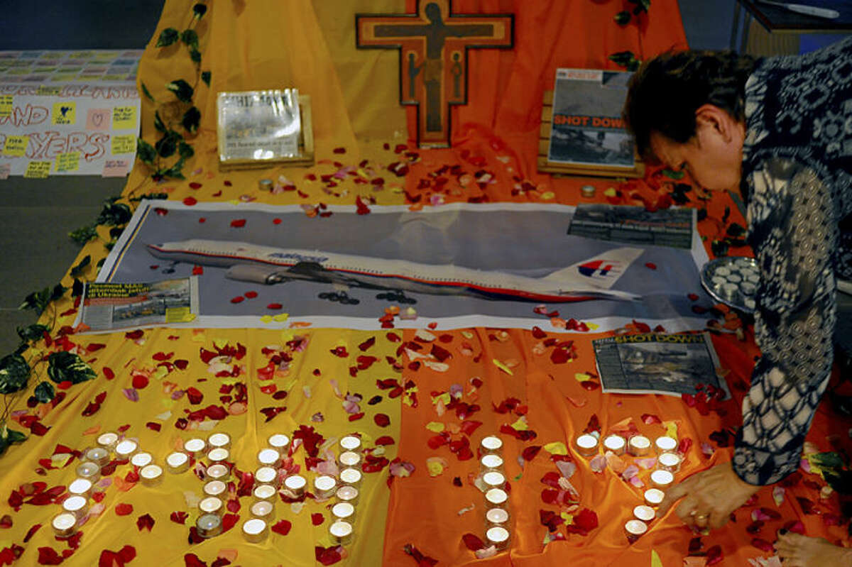Candles are placed for a prayer for victims of the Malaysia Airlines Flight 17 at a church outside Kuala Lumpur, Malaysia, Friday, July 18, 2014. The Malaysia Airlines jetliner was carrying 298 people when it was shot down over eastern Ukraine on Thursday in eastern Ukraine, sending shockwaves around the world from Malaysia to the Netherlands. (AP Photo/Joshua Paul)