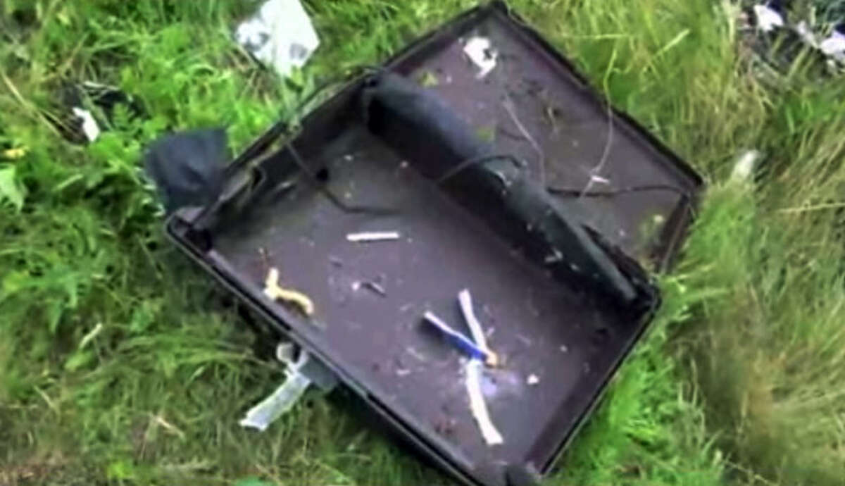 This image taken from video, Thursday July 17, 2014, shows a suitcase found in the wreckage of a passenger plane carrying 295 people after it was shot down Thursday as it flew over Ukraine, near the village of Hrabove, in eastern Ukraine. Malaysia Airlines tweeted that it lost contact with one of its flights as it was traveling from Amsterdam to Kuala Lumpur over Ukrainian airspace. (AP Photo/Channel 1) RUSSIA OUT - TV OUT
