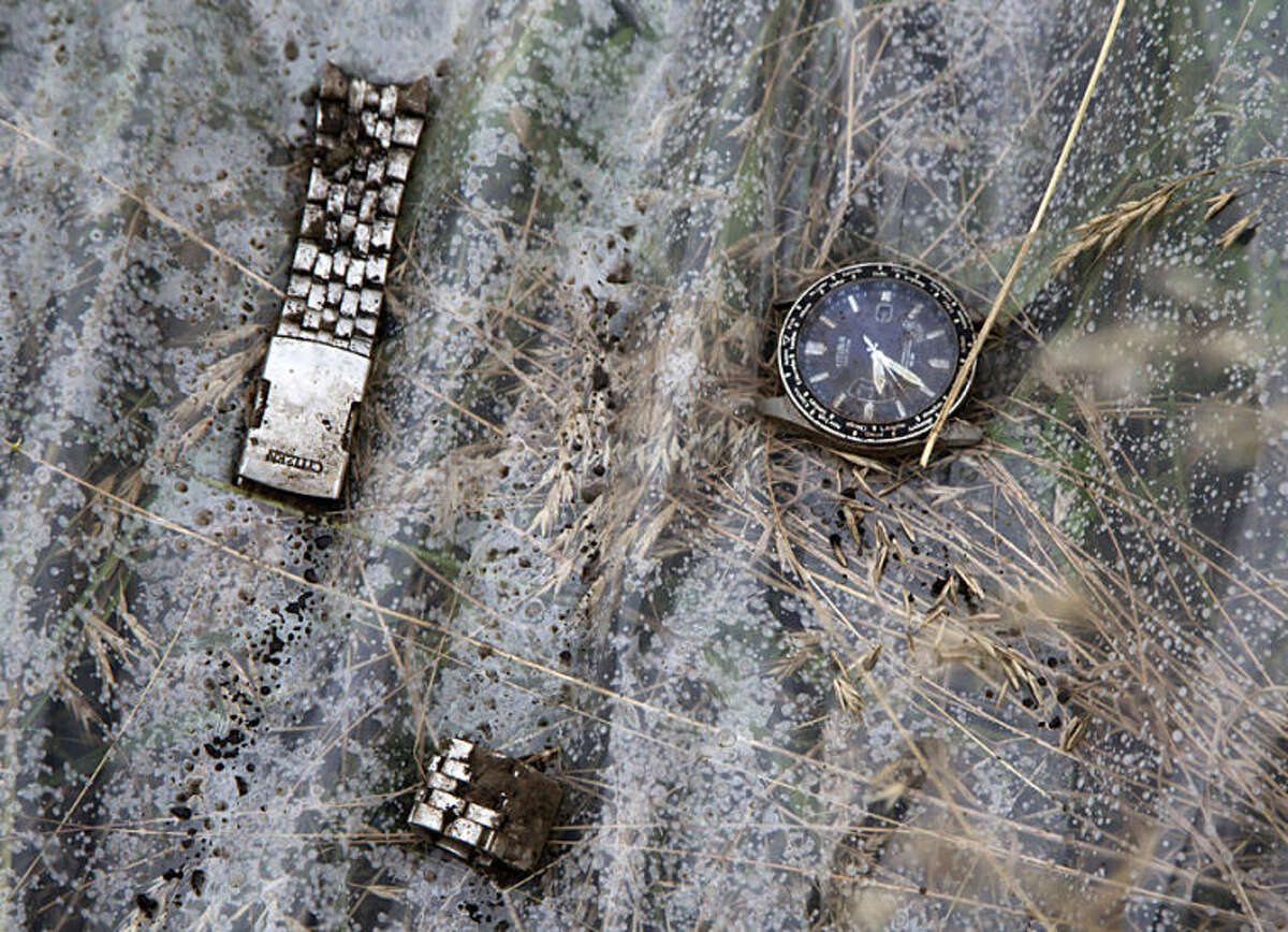 A watch and a part of bracelet lie on a plastic cover at the site of a crashed Malaysia Airlines passenger plane near the village of Rozsypne, Ukraine, eastern Ukraine Friday, July 18, 2014. Rescue workers, policemen and even off-duty coal miners were combing a sprawling area in eastern Ukraine near the Russian border where the Malaysian plane ended up in burning pieces Thursday, killing all 298 aboard. (AP Photo/Dmitry Lovetsky)