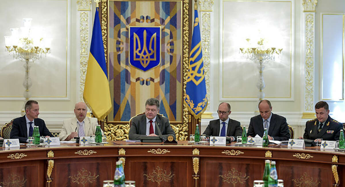 Ukrainian President Petro Poroshenko, third left, chairs a Security Council meeting in Kiev, Ukraine, Thursday, July 17, 2014. Ukrainian President Petro Poroshenko called the downing of a Malaysia Airlines passenger plane an act of terrorism and called for an international investigation into the crash. Poroshenko insisted that his forces did not shoot down the plane. From right, Ukrainian Defense MInister Valery Heletey, Head of the Security Council Andriy Parubiy, Prime Minister Arseniy Yatsenyuk, Petro Poroshenko, parliament speaker Oleksandr Turchynov. (AP Photo/Presidential Press Service, Mykola Lazarenko)