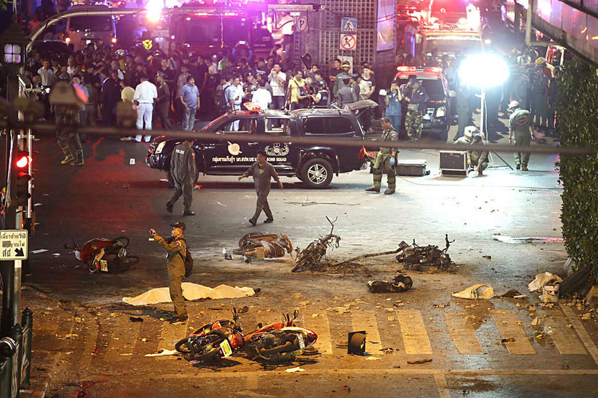 A policeman photographs debris from an explosion in central Bangkok, Thailand, Monday, Aug. 17, 2015. A large explosion rocked a central Bangkok intersection during the evening rush hour, killing a number of people and injuring others, police said. (AP Photo/Mark Baker)