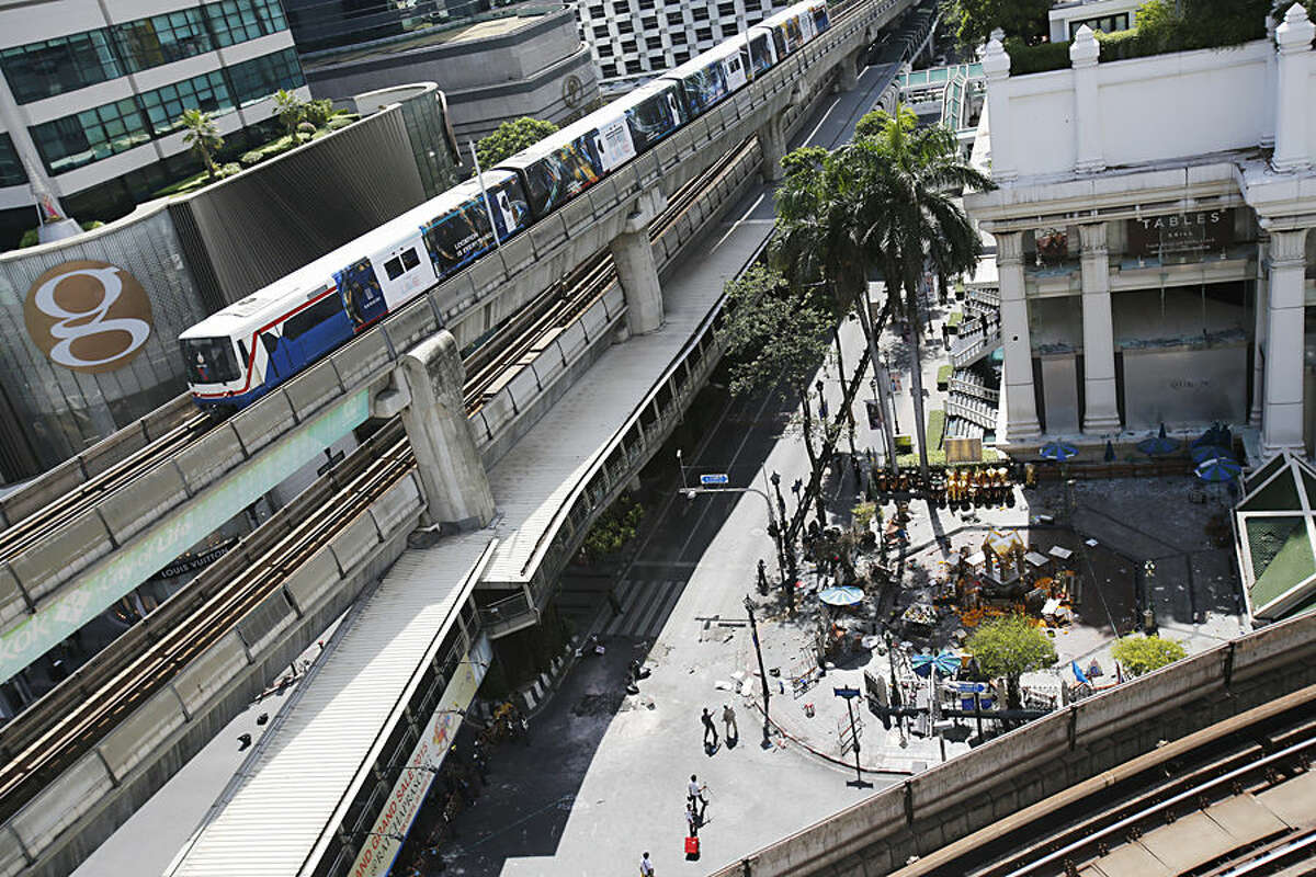 The Erawan Shrine, right, and Rajprasong intersection remains closed in Bangkok, Thailand, Tuesday, Aug. 18, 2015, as investigations continue the morning after an explosion. Thailand's prime minister on Tuesday promised that authorities would quickly track down those responsible for the central Bangkok bombing which he described as the country's worst attack ever. (AP Photo/Sakchai Lalit)