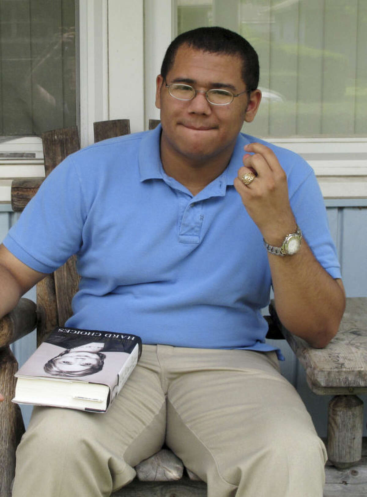 David Vernon, 18, takes a break while reading on his porch in Columbus, Ohio, on Monday, July 21, 2014. Both Republicans and Democrats are seeking voters like Vernon, a self-described moderate and an avid social media user who says he has seen a steady increase in tweets from both parties aimed at attracting younger African-American voters to get involved in political campaigns. (AP Photo)