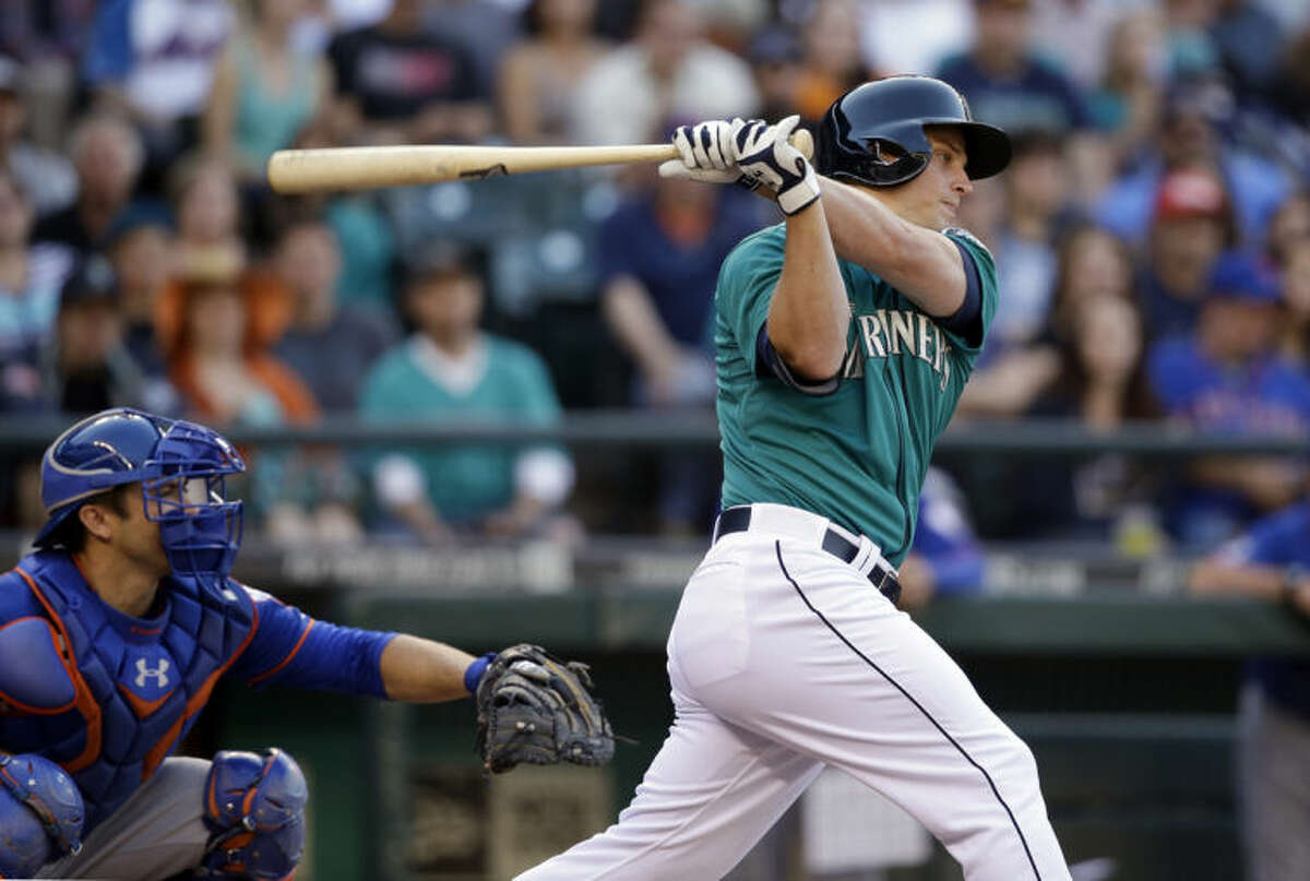 Seattle Mariners' Kyle Seager singles in a run as New York Mets catcher Travis d'Arnaud looks on in the first inning of a baseball game Monday, July 21, 2014, in Seattle. (AP Photo/Elaine Thompson)