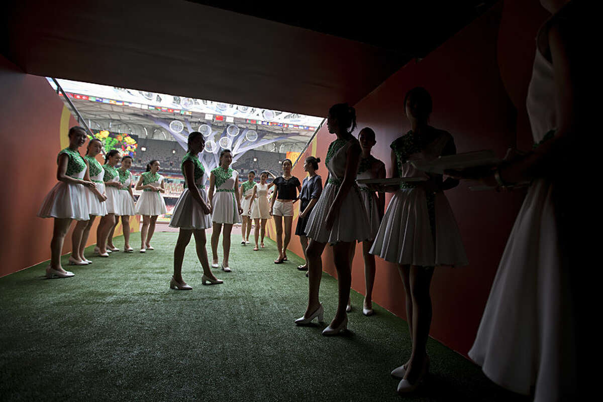 Attendants prepare to walk into the iconic Bird's Nest National Stadium during a rehearsal of medal presentation ceremonies for the upcoming 15th IAAF Athletics World Championships in Beijing Tuesday, Aug. 18, 2015. The sport event will be held in Beijing from August 22 to 30. (AP Photo/Andy Wong)