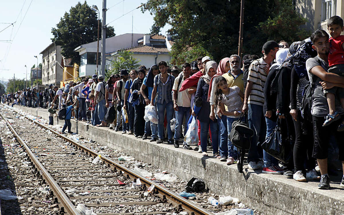 Migrants line up to board a train that would take them towards Serbia, at the railway station in the southern Macedonian town of Gevgelija, on Monday, Aug. 17, 2015. Over 1,000 migrants from Middle East, Asia and Africa, enter Macedonia daily from Greece, heading north through the Balkans on their way to the more prosperous European Union countries. (AP Photo/Boris Grdanoski)