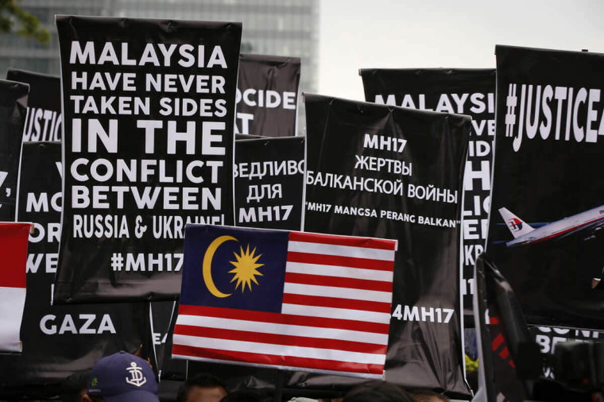 Banners are held up by protesters during a protest in front of Ukraine embassy in Kuala Lumpur, Malaysia, Tuesday, July 22, 2014. Protesters marched on the Russian embassy and Ukraine embassy in Kuala Lumpur on Tuesday, waving placards and demanding justice for the victims of the Malaysia Airlines flight that was shot down over Ukraine last week. (AP Photo/Vincent Thian)