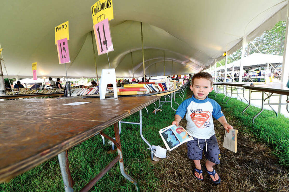 Hour photo / Erik Trautmann Wesport resident 2 year old Jacob Hantler finds some half price books on the last day of the Westport Public Library BOOKstravaganza: The Annual Gigantic Summer Book Sale at Jesup Green Monday.