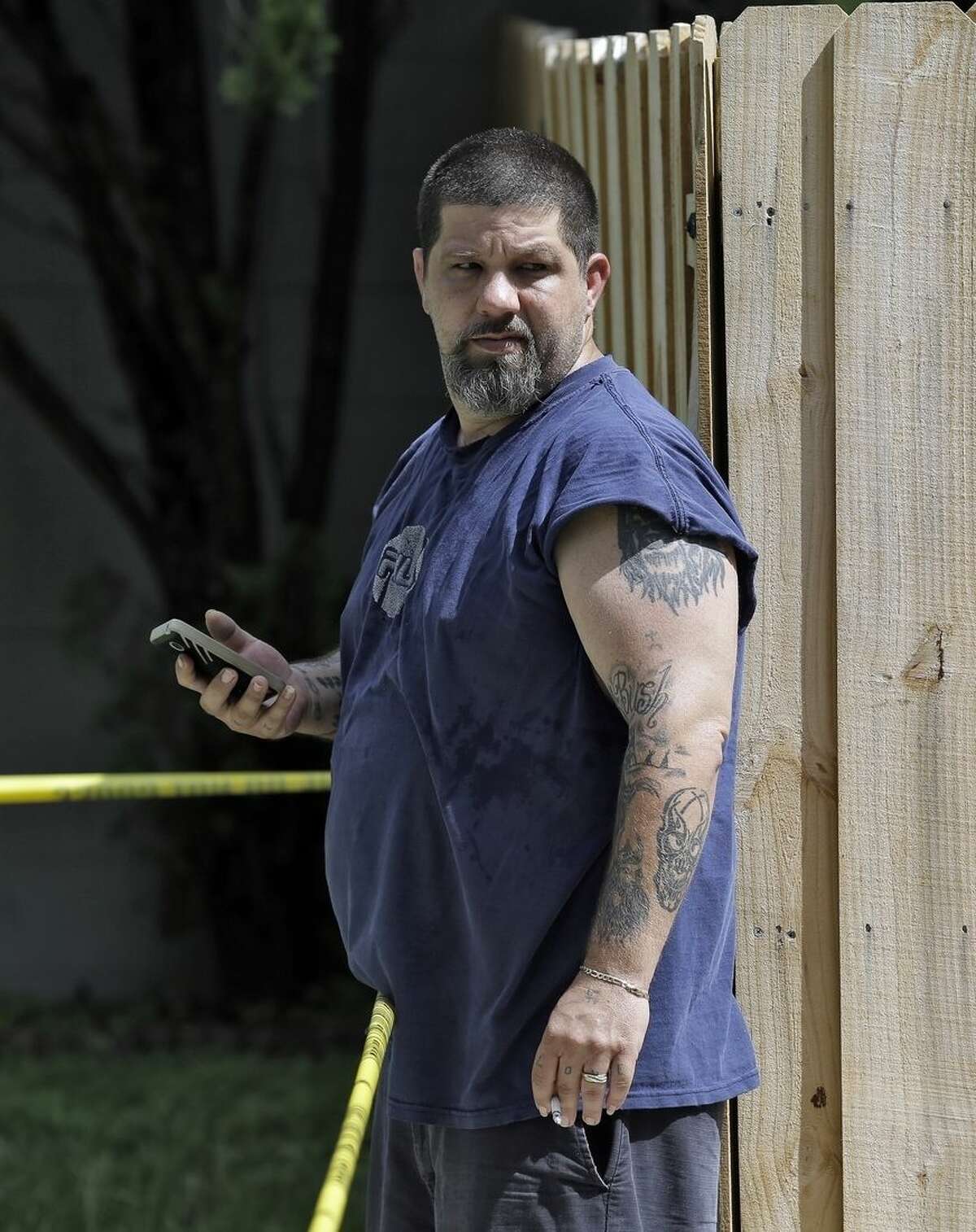 Jeremy Bush watches as members of the Hillsborough County Code Enforcement survey the property where a sinkhole reopened, Wednesday, Aug. 19, 2015, in Seffner, Fla. The sinkhole reopened in the exact same location where one swallowed Jeremy's brother Jeffrey Bush, as he slept in his bed more than two years ago. The new hole is 17 feet wide by 20 feet deep, according to code enforcement director Ron Spiller. In March 2013, Jeffrey Bush was asleep in his bedroom on the property when the floor collapsed and he fell in. His body was never recovered. (AP Photo/Chris O'Meara)