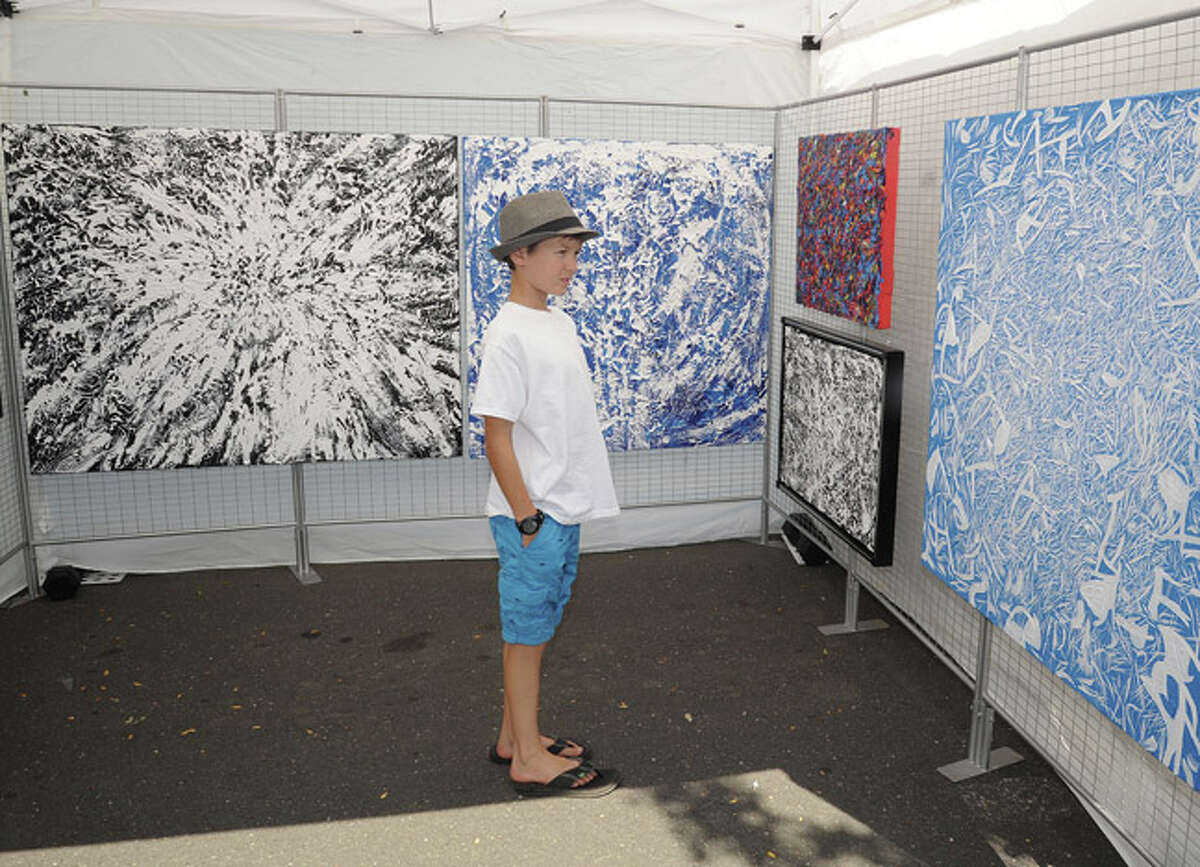 Graham Olenstein 11, admiring paintings Sunday at the Westport Arts Festival. Hour photo/Matthew Vinci