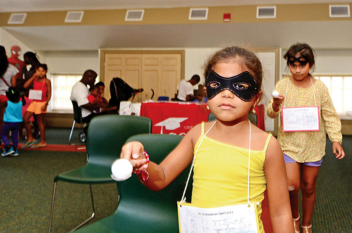 Hour photo / Erik Trautmann Sage Smith, 5, and Ariana Mesa, 7, look to complete the superhero mission obstacle course during the Back to School Celebration for children in grades K - 5 at the SoNo Library Saturday sponsored by the library and ConnCAN (The Connecticut Coalition for Achievement Now).