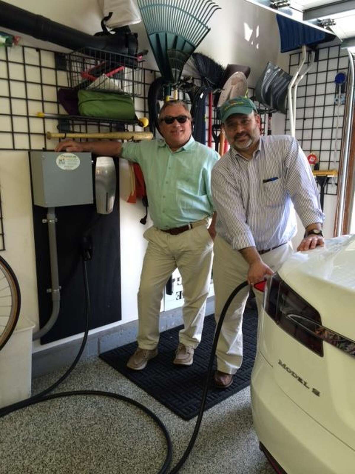 Photo: Ed Ingalls, owner of CT Electric Car, a division of Newington Electric, visits with Tesla electric vehicle owner Seth Diamond after the installation of a car charging station at his Glastonbury, CT home. CT Electric Car has been selected as one of Tesla's recommended car charging station installers.   
