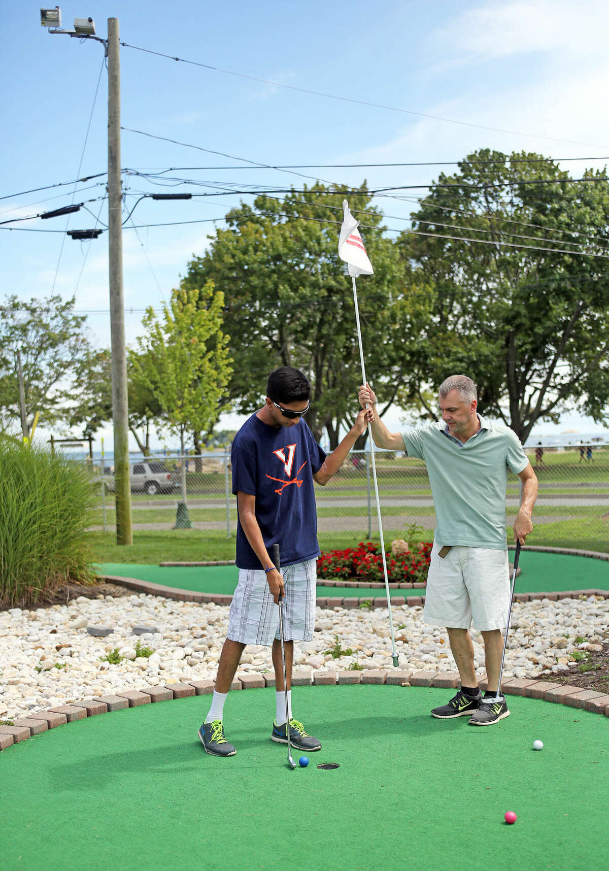 Steve Gatto plays a round with her Sanjeev Jariwala at Norwalk Cove Marina Mini Golf Sunday afternoon. Hour Photo / Danielle Calloway