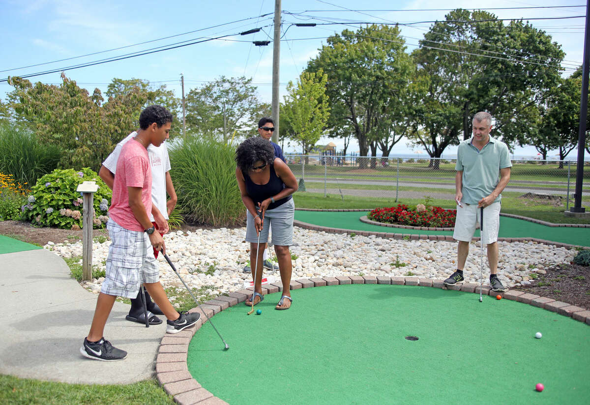 Carla Gatto plays a round with her family at Norwalk Cove Marina Mini Golf Sunday afternoon. Hour Photo / Danielle Calloway
