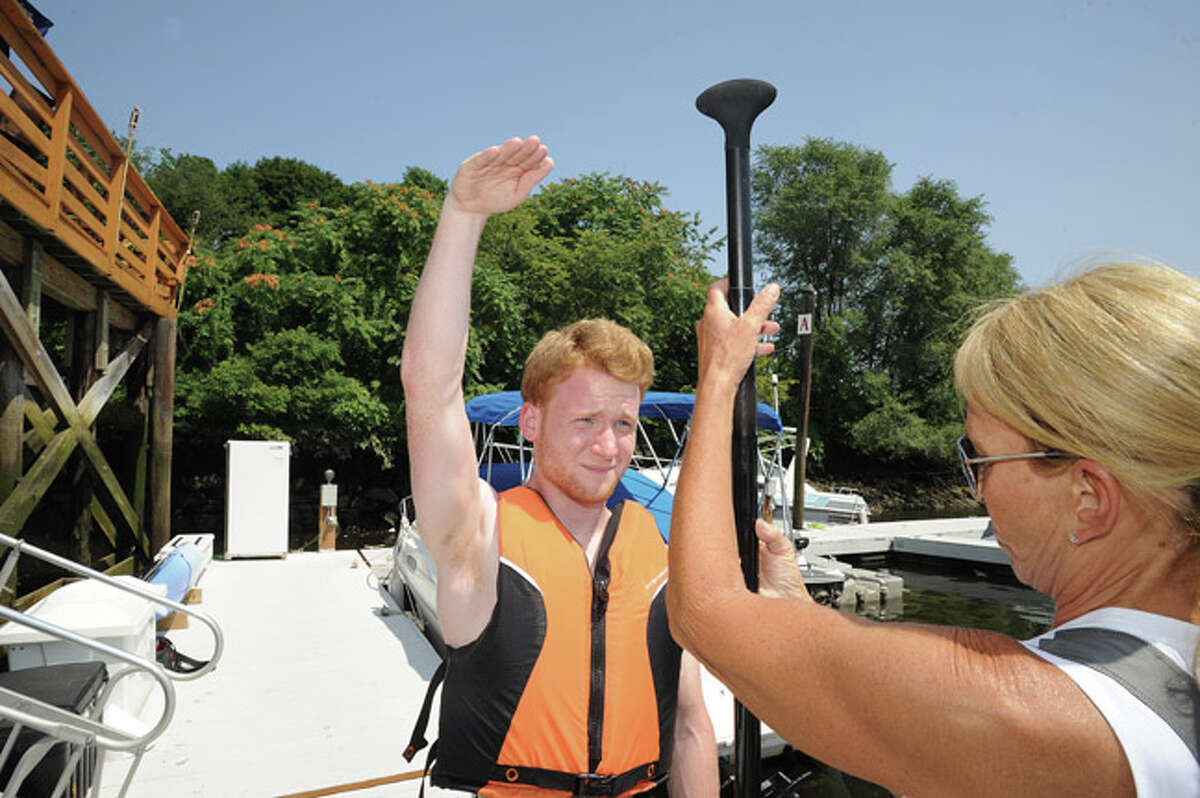 Hour Correspondent Justin McCabe learning to paddleboard on the Norwalk River from instructor Nancy Breakstone from the Norwalk Boat Club. Hour photo/Matthew Vinci