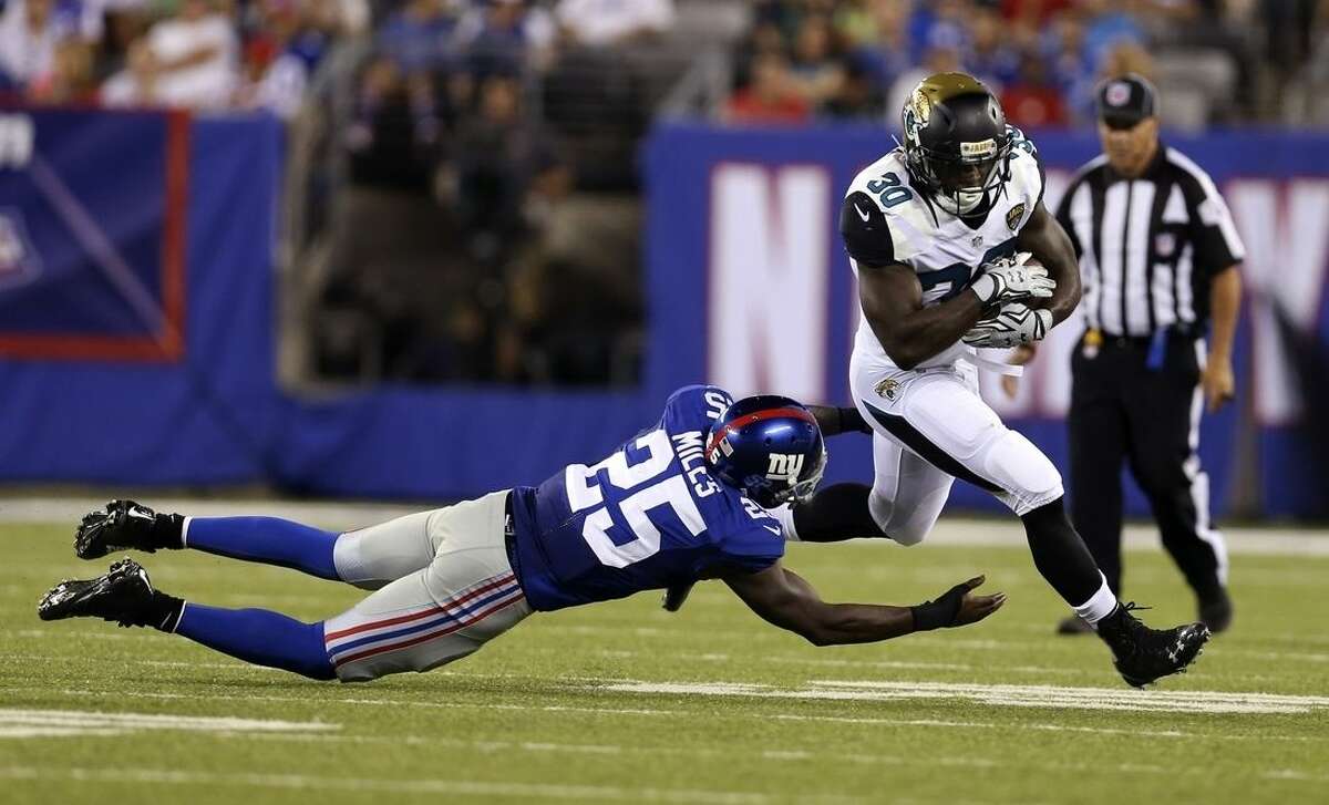 Jacksonville Jaguars' Bernard Pierce (30) breaks a tackle by New York Giants' Jeromy Miles (25) during the first half of a preseason NFL football game Saturday, Aug. 22, 2015, in East Rutherford, N.J. (AP Photo/Adam Hunger)