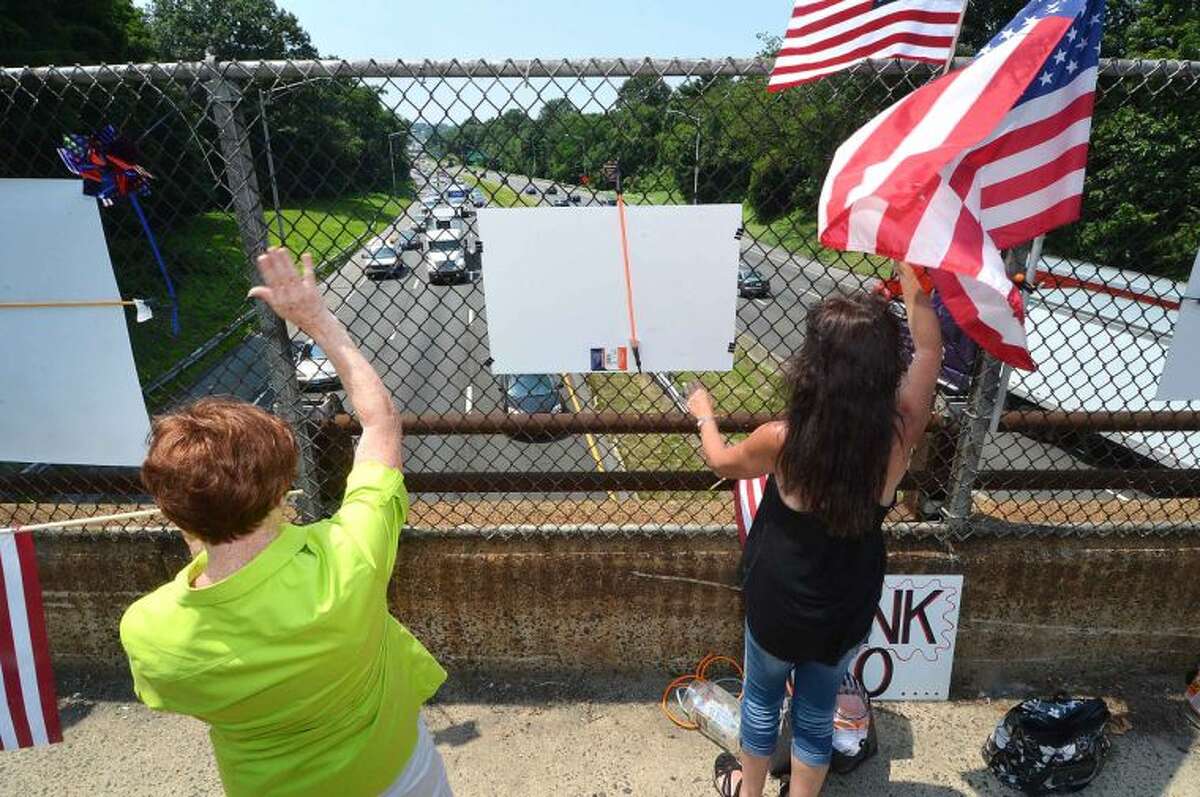 Hour Photo/Alex von Kleydorff On Strawberry Hill ave Friday, Nancy Krysiak and Brenda Gaffney get the attention of motorists on I95 Northbound as they honk their horns in support. The New England Overpasses for America group were protesting immigration amnesty for the recent wave of children crossing the border into the US
