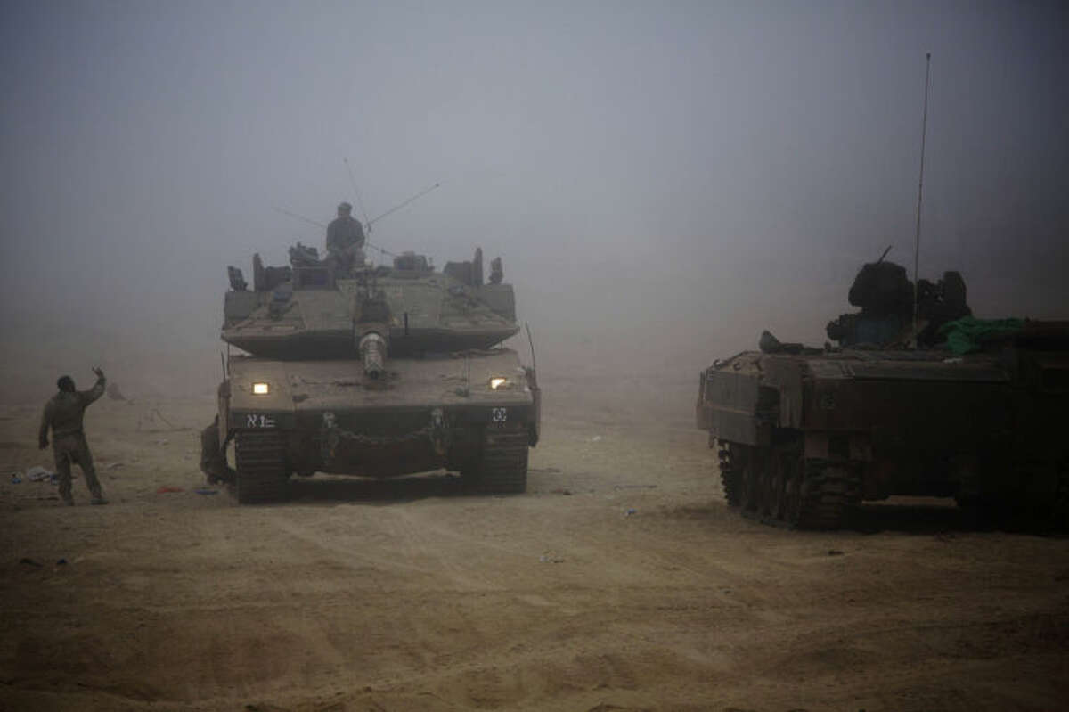 An Israeli tank moves through the morning mist near the Israel and Gaza border Thursday, July 24, 2014. Israeli tanks and warplanes bombarded the Gaza Strip on Thursday, as Hamas militants stuck to their demand for the lifting of an Israeli and Egyptian blockade in the face of U.S. efforts to reach a cease-fire. (AP Photo/Dusan Vranic)