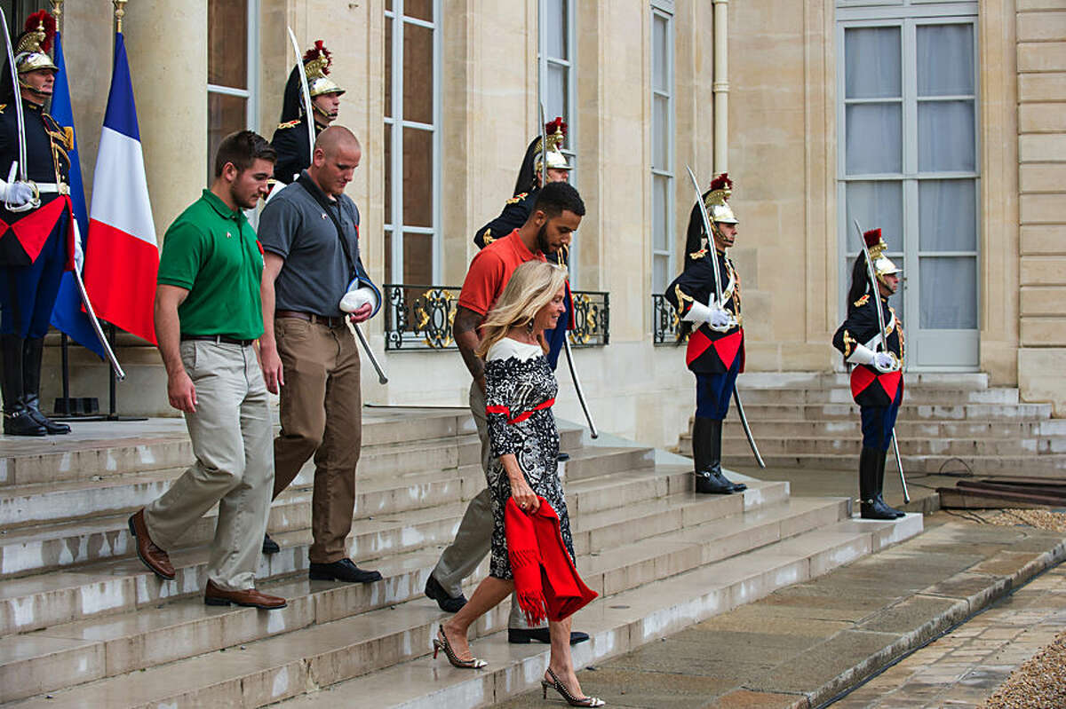 CORRECTS SADLER’S SCHOOL TO SACRAMENTO STATE UNIVERSITY, INSTEAD OF SACRAMENTO UNIVERSITY - U.S. National Guardsman from Roseburg, Ore., Alek Skarlatos, left, U.S. Airman Spencer Stone, second left, and Anthony Sadler, right, a senior at Sacramento State University in California, leave the Elysee Palace in Paris, France, with U.S. Ambassador to France Jane D. Hartley after being awarded the French Legion of Honor by French President Francois Hollande on Monday, Aug. 24, 2015. The three American travelers say they relied on gut instinct and a close bond forged over years of friendship as they took down a heavily armed man on a passenger train speeding through Belgium on Friday, Aug. 21. (AP Photo/Kamil Zihnioglu)