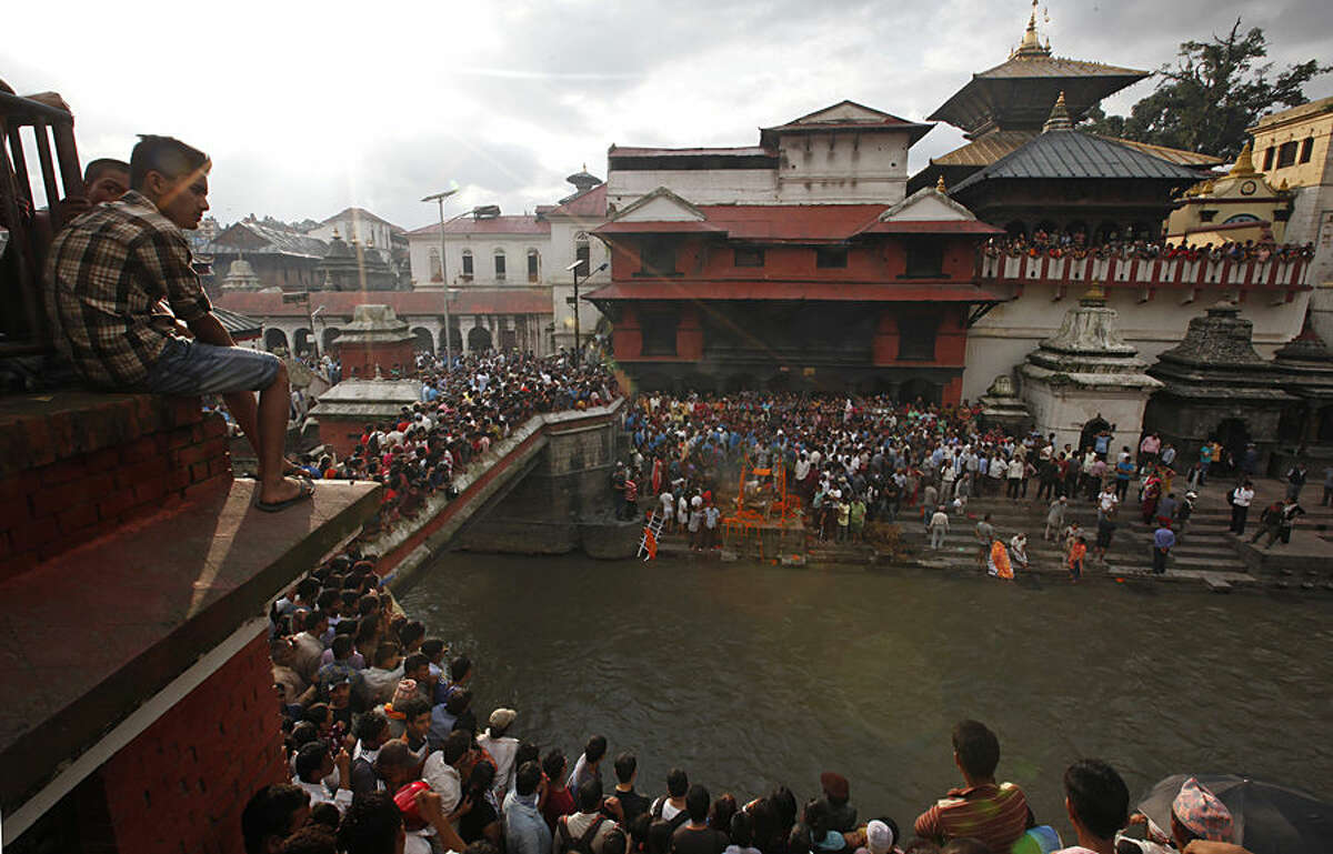 Nepalese people gather near Pashupatinath temple during the cremation of Laxman Neupane, one among the police officers killed in Monday’s clashes in western Nepal, in Kathmandu, Nepal, Tuesday, Aug. 25, 2015. Ethnic protesters, demanding statehood, attacked police with spears and knives a day earlier in Tikapur, 400 kilometers (250 miles) west of Kathmandu. (AP Photo/Niranjan Shrestha)