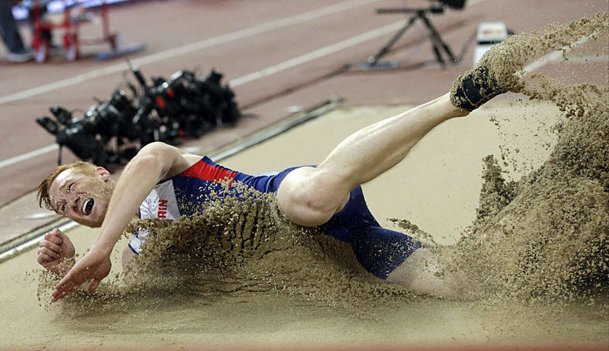 Britain's Greg Rutherford lands in the sand as he competes in the men’s long jump final at the World Athletics Championships at the Bird's Nest stadium in Beijing, Tuesday, Aug. 25, 2015. (AP Photo/Andy Wong)