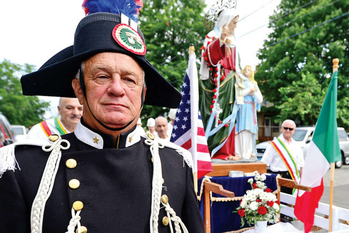 Hour photo / Erik Trautmann Members of St. Ann Club, including John Johnson, parade to and from St. Thomas Church as part of the annual St. Ann Club's Italian Feast on Hendricks Avenue this weekend.