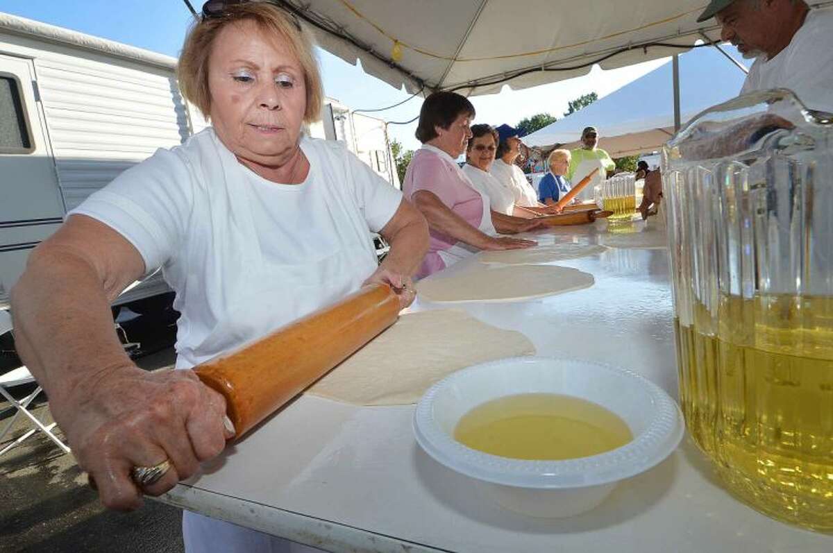 Hour Photo/Alex von Kleydorff Maria Cundari one of the many ladies in charge of rolling the dough paper thin for Pizza Fritta, and keeps the olive oil nearby so they are perfect. The St. Ann Club Feast celebrates it's Centennial anniversary this weekend