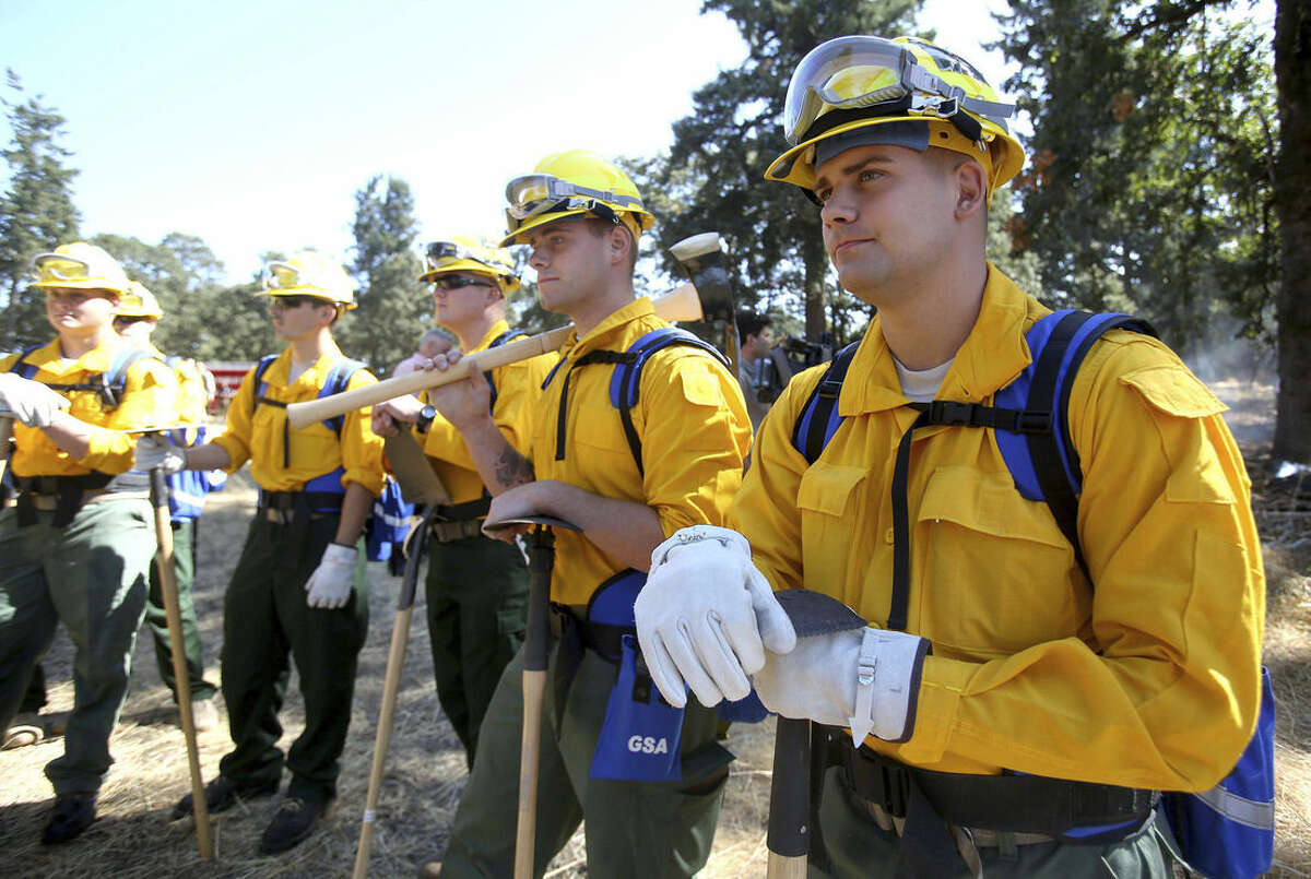 Oregon National Guard Spc. Nicholas Hall, right, listens to an instructor during wildland fire training Tuesday, Aug. 25, 2015, in Salem, Ore. Gov. Kate Brown is activating additional Oregon National Guard members to help fight destructive wildfires raging across the state. (Ashley Smith/Statesman-Journal via AP)