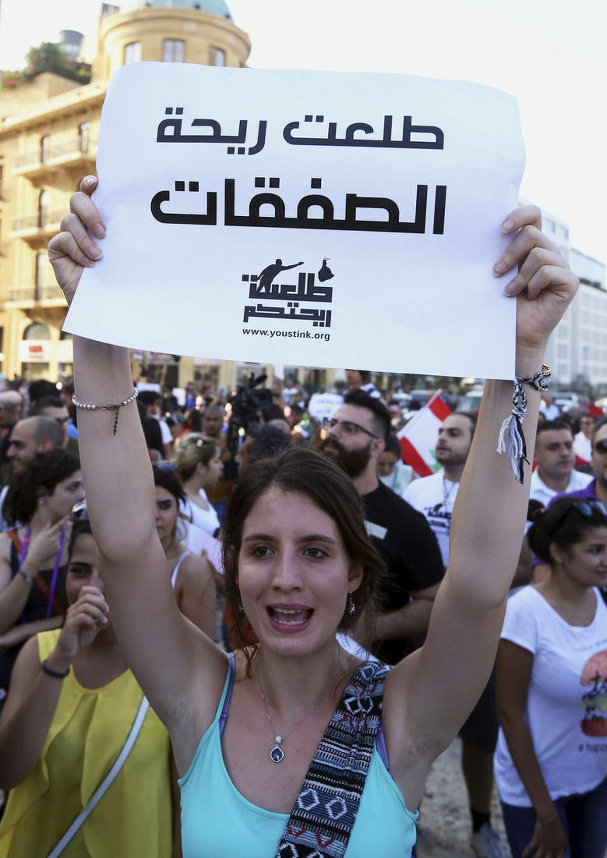 FILE - In this Saturday, Aug. 8, 2015 file photo, a Lebanese protester chants slogans against the Lebanese government during a demonstration against the ongoing trash crisis, at the Martyrs square in downtown Beirut, Lebanon. Starting out as a small group of tech-savvy young activists who organized to protest the garbage that for weeks has been piling up on Beirut’s streets, Lebanon's "You Stink" movement has now grown into a popular uprising that seeks to nip at the power base of an entire political class. Sign in Arabic reads 'The deals stink'. (AP Photo/Bilal Hussein, File)