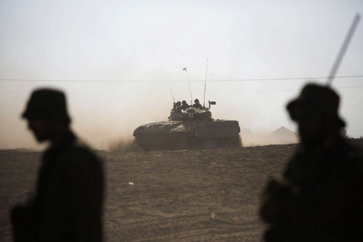 Israeli tank rides near the Israel and Gaza border Friday, July 25, 2014. Early Friday, Israeli warplanes struck tens of houses throughout the Gaza Strip as international efforts continue to broker a cease fire in the 18 day-old war. (AP Photo/Dusan Vranic)