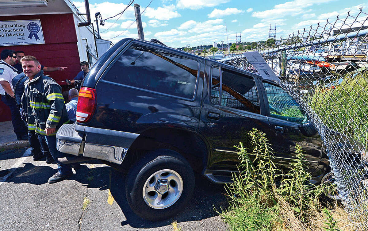 Hour photo / Erik Trautmann Two SUVs go into Norwalk Harbor after a motor vehicle accident outside of Overton's eatery on Seaview Ave Friday afternoon.
