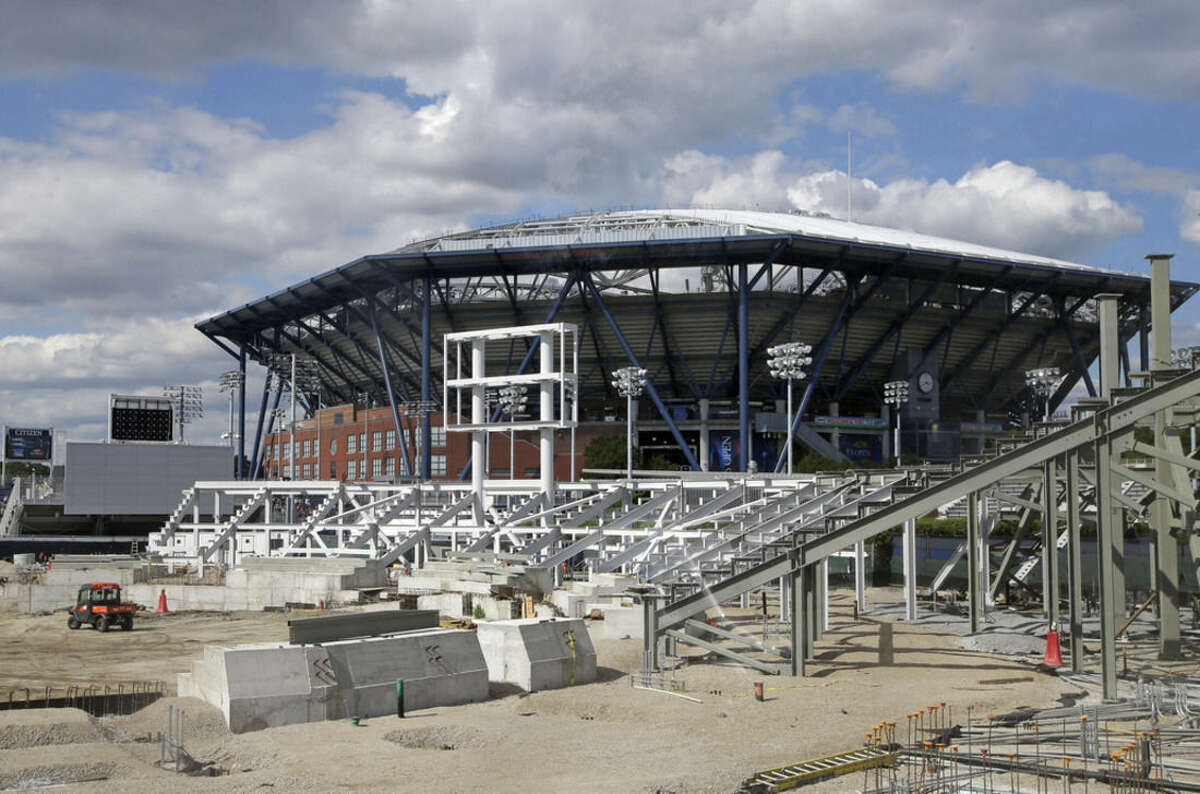 Among the changes that will be visible to tennis fans at the 2015 U.S. Open tennis tournament, construction continues on the new Grandstand court in the southwest corner of the USTA Billie Jean King National Tennis Center in New York, Thursday, Aug. 27, 2015. But the biggest change is a partially completed retractable roof over Arthur Ashe stadium, visible in the background. (AP Photo/Kathy Willens)