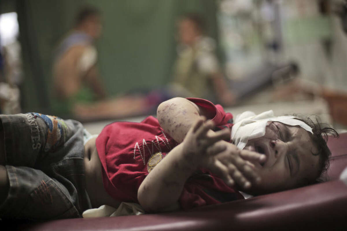 A Palestinian boy cries while receiving treatment for injuries caused by an Israeli strike at a U.N. school in Jebaliya refugee camp, at the Kamal Adwan hospital in Beit Lahiya, northern Gaza Strip, Wednesday, July 30, 2014. Several Israeli tank shells slammed into the crowded U.N. school used as shelter for refugees in the Gaza war early on Wednesday. (AP Photo/Khalil Hamra)