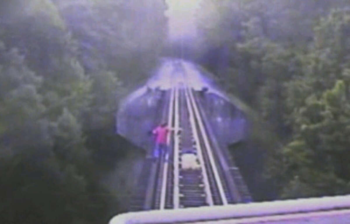 In this frame grab from surveillance video provided by the Indiana Rail Road via WRTV, two women run down a railroad track ahead of a freight train coming toward them, Thursday, July 10, 2014, in Monroe County in Indiana. The women survived the incident, but authorities are reviewing the video for potential criminal charges. (AP Photo/Indiana Rail Road via WRTV)