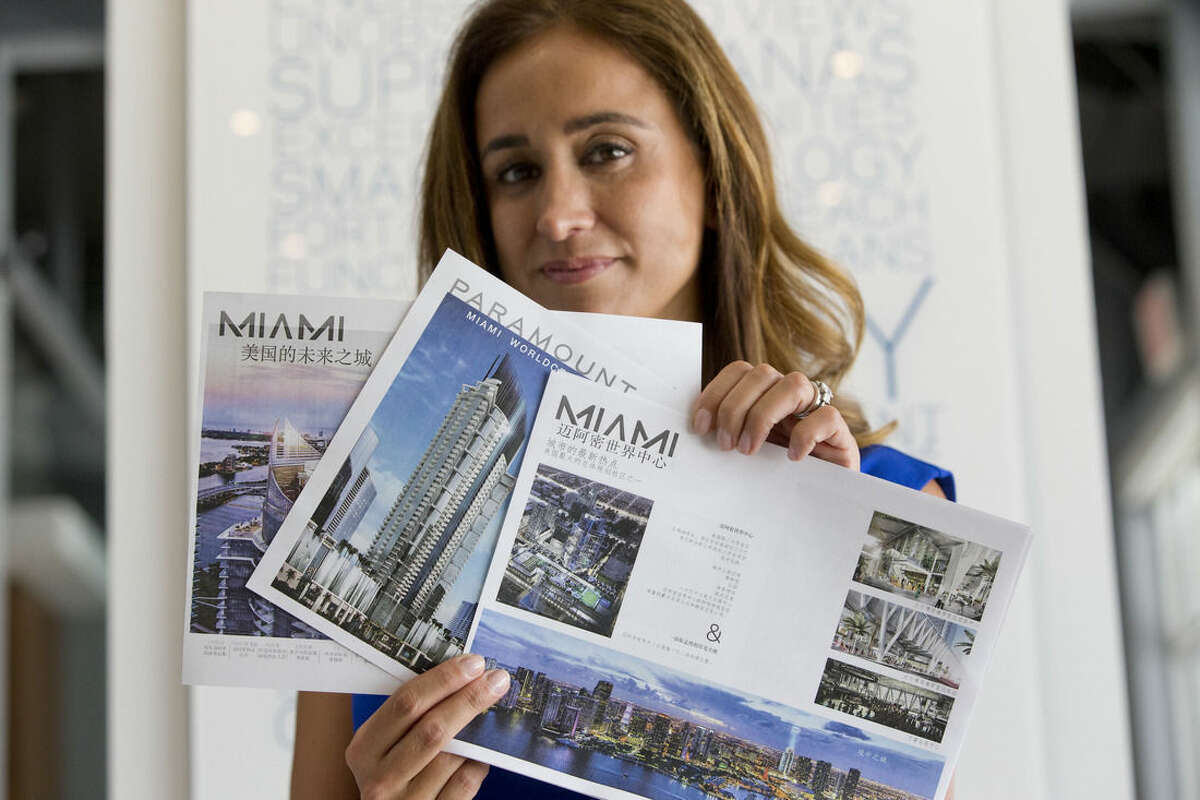 Peggy Fucci, CEO of OneWorld Properties, holds brochures written in Chinese for the Paramount Miami Worldcenter, in Fort Lauderdale, Fla. A nearly 40 percent plunge in the Shanghai stock market since mid-June has sent Chinese investors looking for safer investments. Some are focusing on U.S. real estate, including the condos Fucci’s real estate brokerage sells in Miami. She’s sold six condos to Chinese buyers in the past month, twice the number she’s typically sold. (AP Photo/Wilfredo Lee)