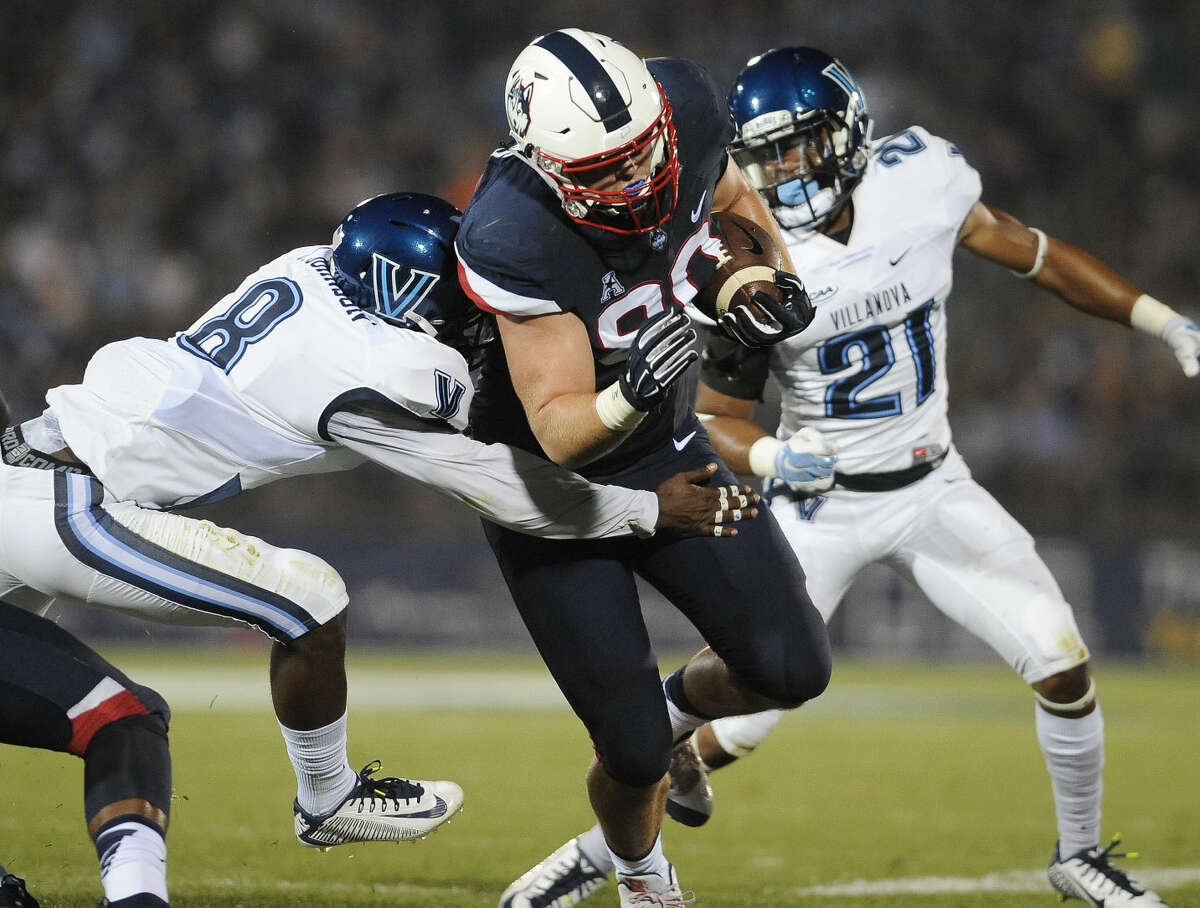 Connecticut tight end Tommy Myers (80) pulls away from Villanova defensive back Trey Johnson (8), left, for a touchdown, as Wesley Smith, right, pursues, during the first half of an NCAA college football game at Pratt & Whitney Stadium at Rentschler Field, Thursday, Sept. 3, 2015, in East Hartford, Conn. (AP Photo/Jessica Hill)