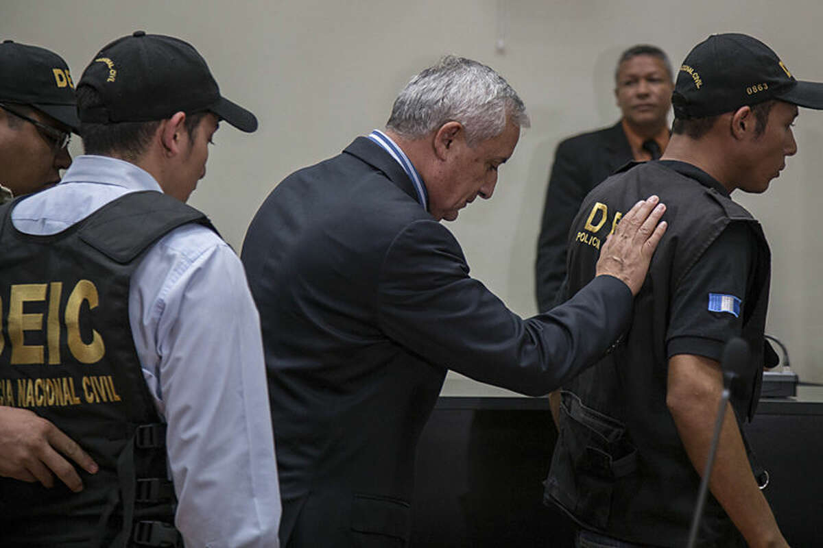 Former President of Guatemala Otto Perez Molina, center, is escorted by police detectives on his way to jail, after a court hearing where he faces corruption charges, in Guatemala City, Thursday, Sept. 3, 2015. Perez Molina was detained overnight before the hearing was to resume Friday morning. Judge Miguel Angel Galvez cited a need to “ensure the continuity of the hearing” and guarantee the former president’s personal safety. (AP Photo/Luis Soto)