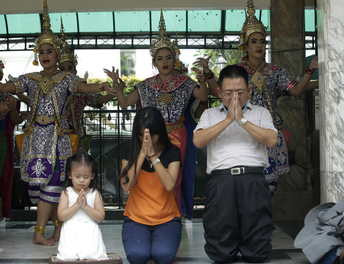 Visitors pray as Thai classical dancers perform at the Erawan Shrine in Bangkok, Thailand, Tuesday, Sept. 1, 2015. Thai authorities arrested a man they believe is part of a group responsible for a bombing at a shrine in central Bangkok two weeks ago, Prime Minister Prayuth Chan-ocha announced Tuesday. (AP Photo/ Sakchai Lalit)